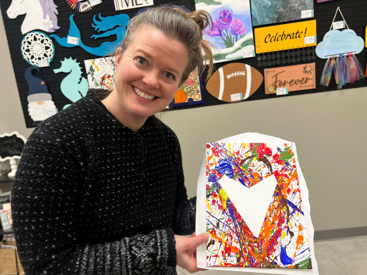 A member of Northern Colorado Community displays a heart shaped splash painting at Pinspiration Loveland