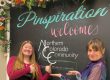 Two "Vana Whites" draw attention to the chalk board located at Pinspiration Loveland that welcomes members of the Northern Colorado Community.