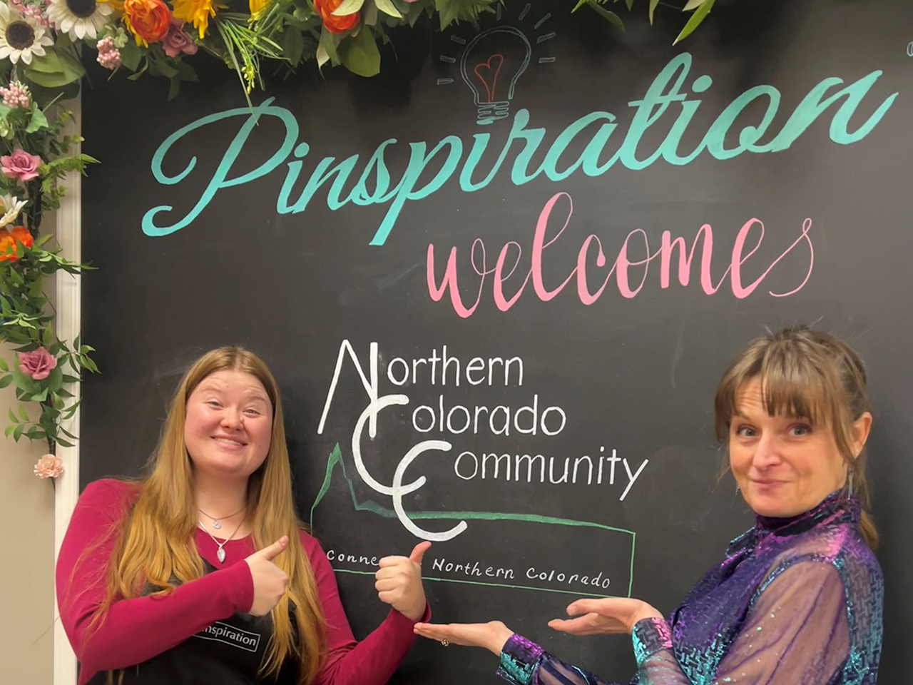 Two "Vana Whites" draw attention to the chalk board located at Pinspiration Loveland that welcomes members of the Northern Colorado Community.